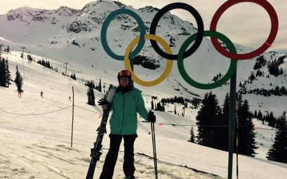 A woman Skiing in snowy mountains by the olympic rings