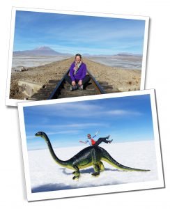 A blonde woman sitting on a deserted train track in a desert setting and with the use of the flat perspective, pretends to slide down the back of a diplodocus dinosaur, Uyuni Salt flats in Bolivia.