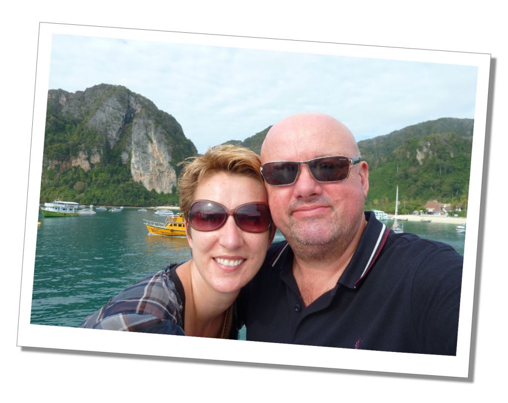 A man and a woman standing cheek to cheek in sunglasses