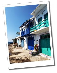 The beautiful multi coloured frontages of the tiny cottages that skirt the shoreline at Klima on the coast of Milos