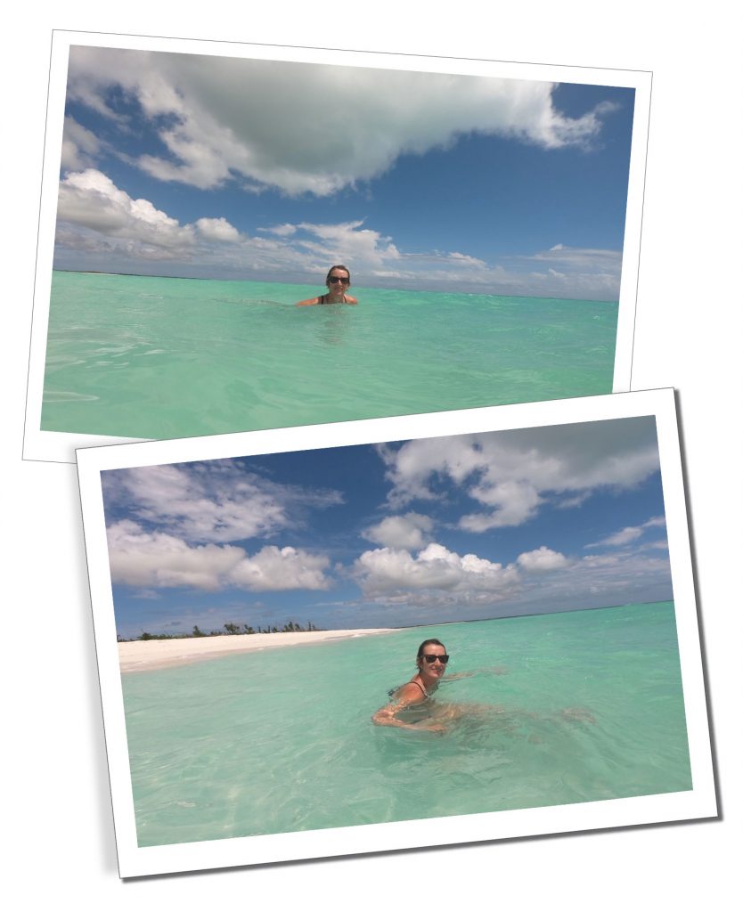 A blonde woman in sunglasses floating in a clear Caribbean sea by a deserted beach