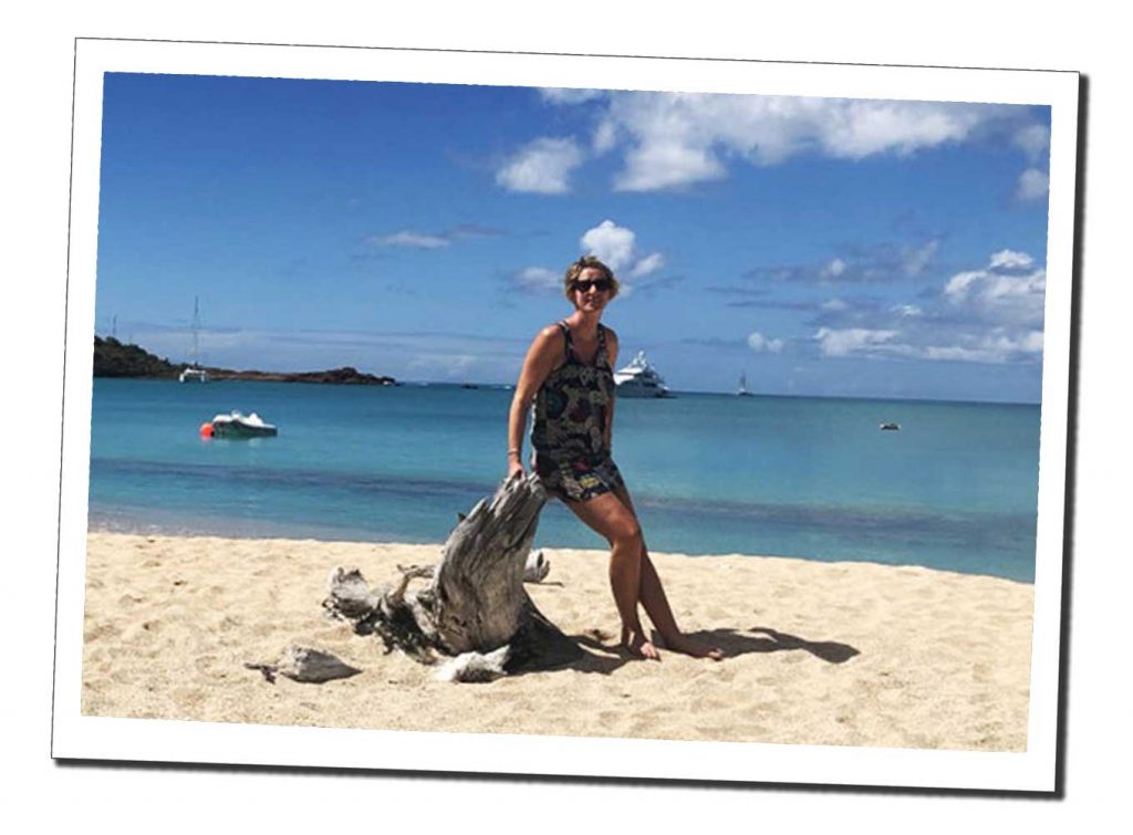 SWWW leans up some drift wood on a sandy beach in a sunny day in Antigua