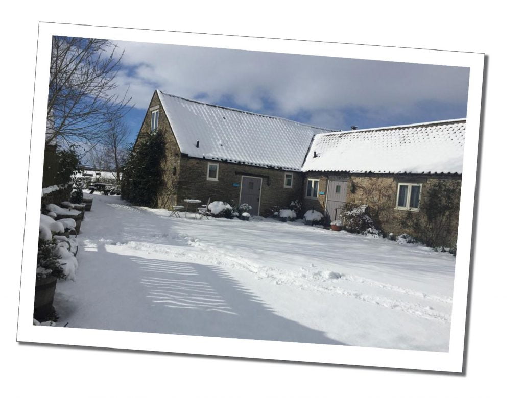 A low level farm cottage set in a snowy landscape