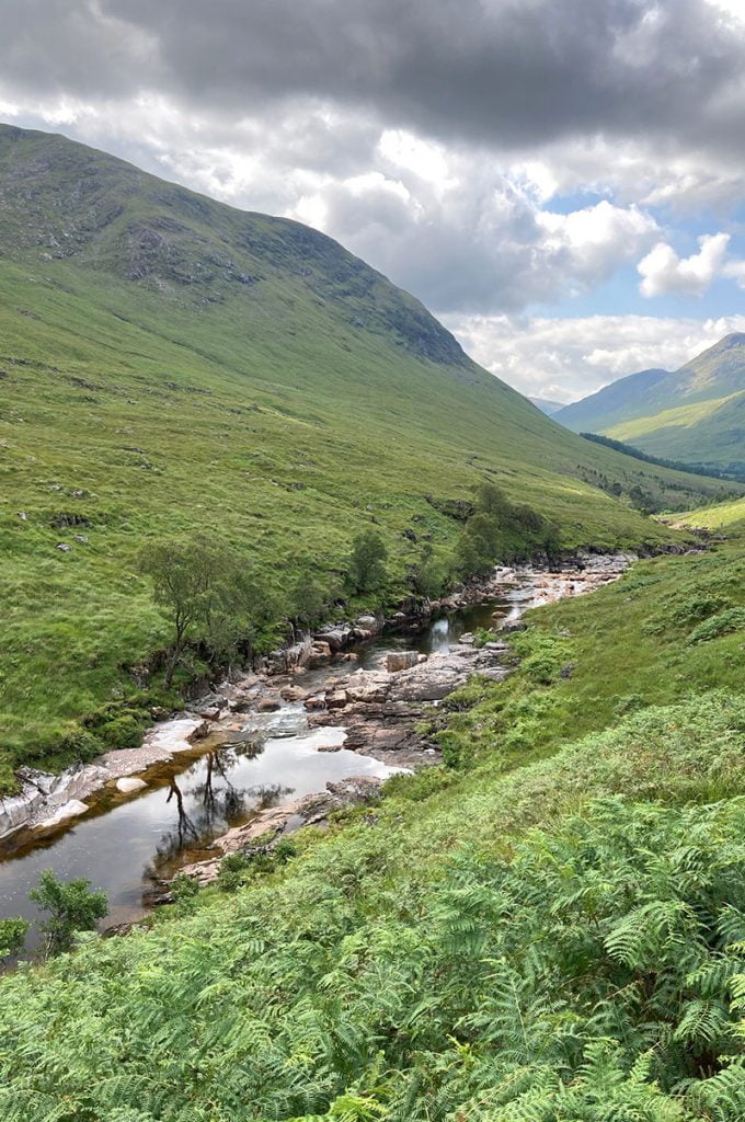 A tiny babbling stream cut through A Breath taking mountainous heather drenched highland scenary