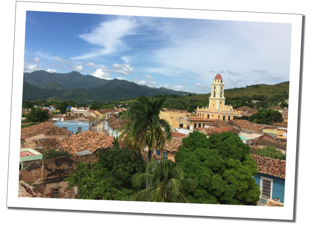 A view of the low roofs, high church and distant mountains, of Trinidad in Cuba