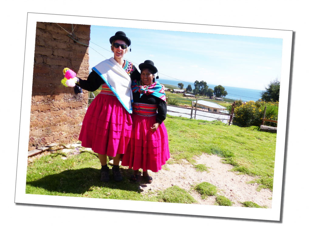 A tall blonde woman and a Cholita standing arm in arm in national costume, Lake Titicaca, Peru