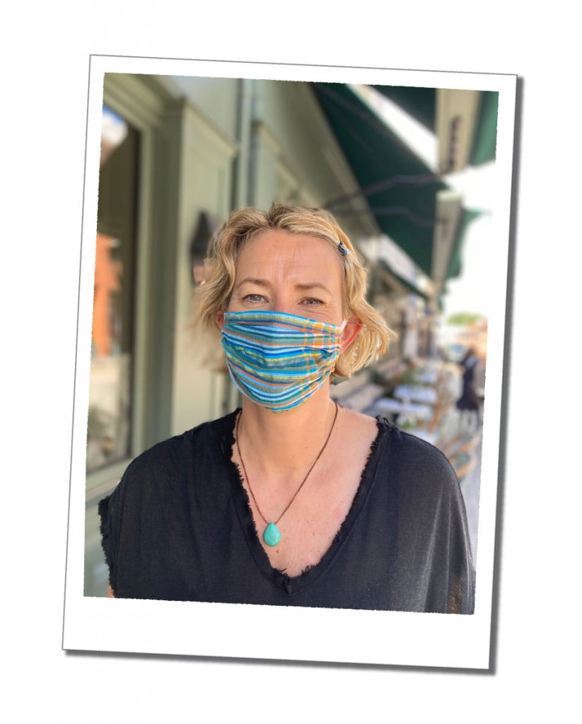 A blond woman, in a blue face mask