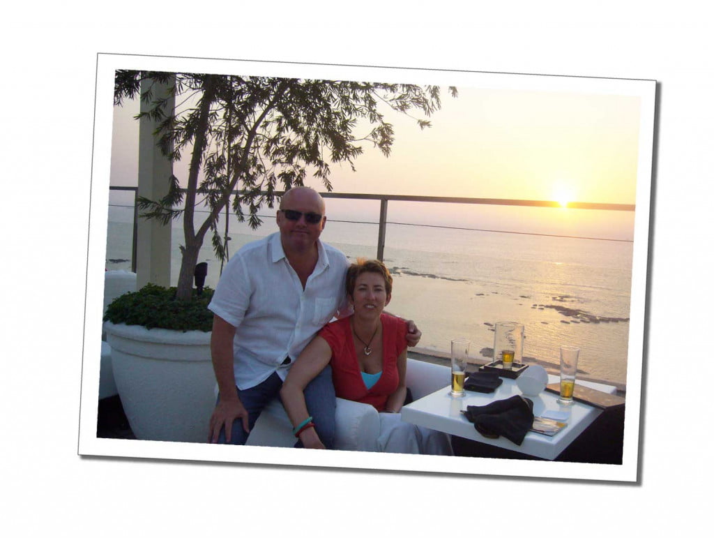 A couple sitting in a restaurant overlooking the sea at sunset