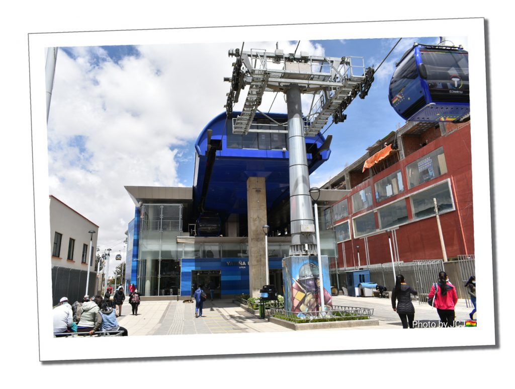 The main station of a Bolivian cable car. With a blue cable car leaving the junction