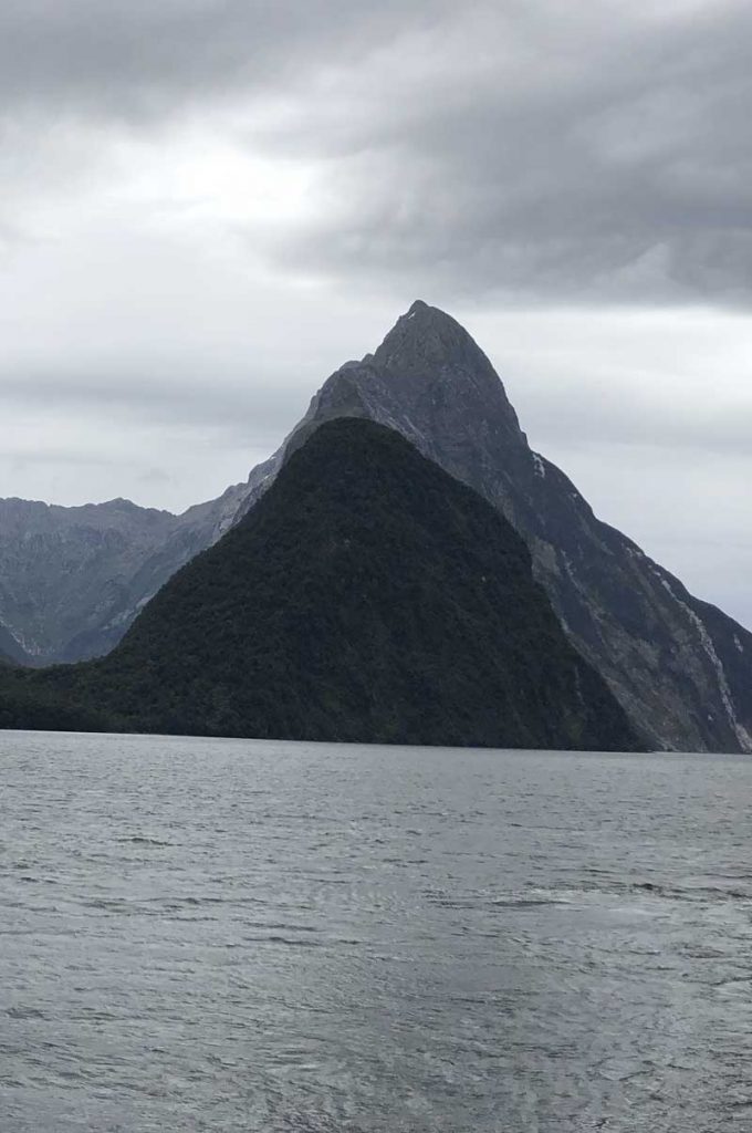 The dark imposing Mitre Peak, Milford Sound looms triangular straight from the shore