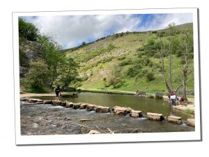 Dovedale Stepping Stones, Peak District Stepping Stones across a babbling river flanked by hills and topped by scudding clouds