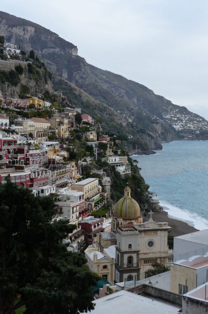 a stepped hillside of brightly coloured houses leading to a dramatic shoreline