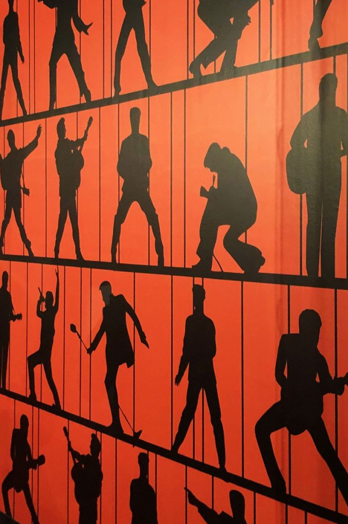 Silhouetted images of Elvis on an orange background