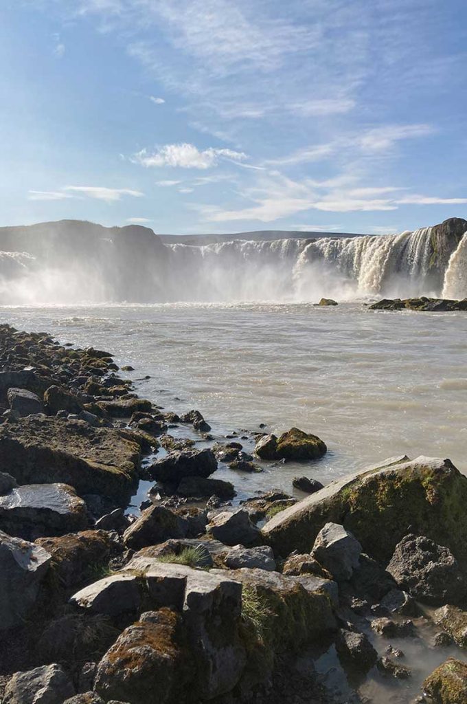 A giant crashing distant waterfall with a rocky foreground