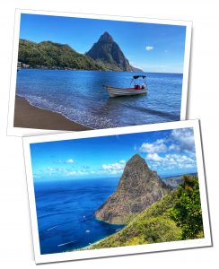 A sandy caribbean beach and a view of a large pointed mountain with small yacht on a tranquil blue sea