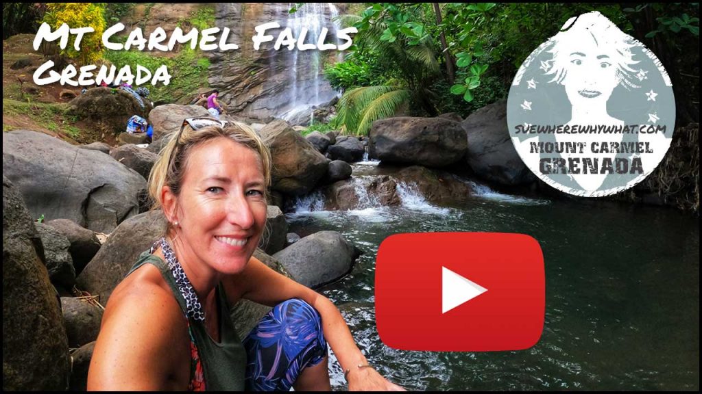 A blonde Woman sin blue trousers and trainers smiling in front of a small waterfall with a large red Youtube button