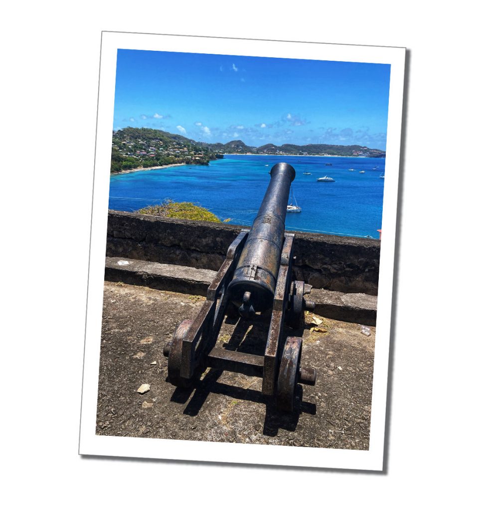 An old canon point out and overlooking a bleu caribbean sea