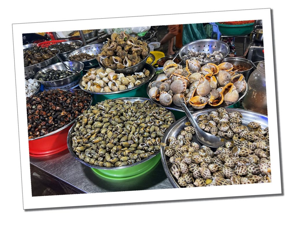 Large overflowing bowls of shelled seafood of all sizes and colours on a table