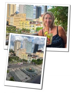A woman drinking a green cocktail with views of tall buildings from the Rex hotel in Saigon