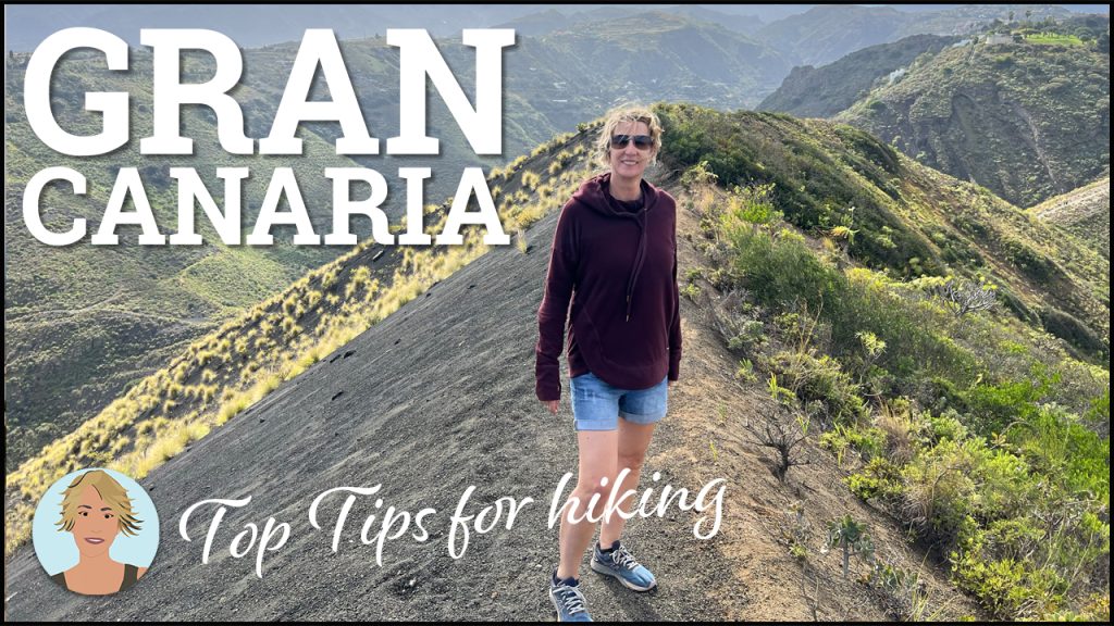 A blonde woman in sunglasses standing on the apex of gravel covered hill